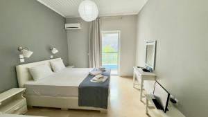 a bedroom with a bed and a television and a table at Ponti Beach Hotel in Vasiliki