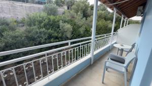 a balcony with a chair and a table and bushes at Ponti Beach Hotel in Vasiliki