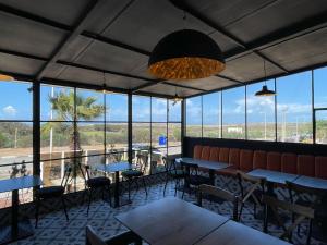 a restaurant with tables and chairs and windows at Little Wing in Diabat