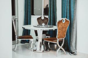 a dining room with a table and two chairs at Le Parvis Résidences in Yaoundé +38 photos