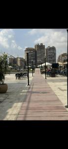 a boardwalk with tables and benches in a city at شقه مفروشه على النيل شارع عبدالعزيز آل سعود in Cairo