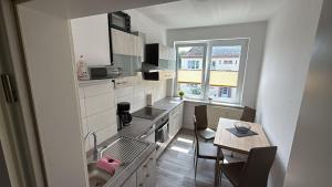 a small kitchen with a table and a dining room at Alinas Ferienwohnung Güstrow in Güstrow