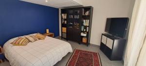 a bedroom with a bed and a flat screen tv at Location Le Tilleul in Pélissanne +9 photos