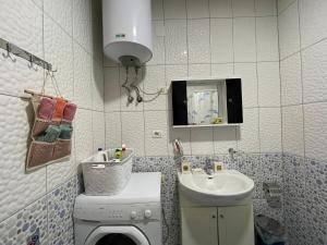 a bathroom with a washing machine and a sink at Dukas apartment in Korçë +26 photos