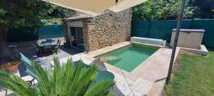 a small pool in a backyard with a table and a bench at Location Le Tilleul in Pélissanne