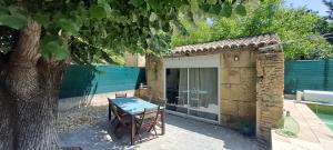 a table in front of a building with a tree at Location Le Tilleul in Pélissanne
