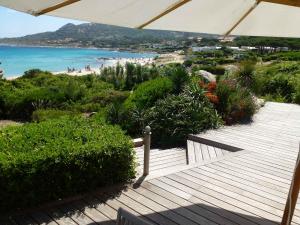 a wooden pathway leading to a beach with an umbrella at Sur la plage in Lumio +15 photos