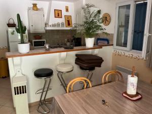 a kitchen with a table and a counter with stools at Les Cigales in Saint-Andiol