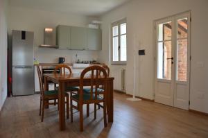 Una cocina con mesa y sillas y un refrigerador. en Casale Pura Vita, en Castiglion Fiorentino