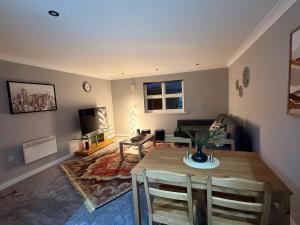 Una sala de estar con una mesa y una sala de estar con un sofá. en Modern Living Near Town Center, en Bracknell