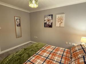 Un dormitorio con una cama y cuadros en la pared. en Modern Living Near Town Center, en Bracknell