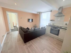 a living room with a couch and a kitchen at Lovely 1 Bed flat in high street - 4 min walk to beach- 300m in Herne Bay
