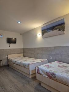 a room with two beds and a tv on the wall at Palanga S3 in Palanga