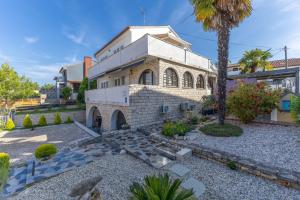 a building with a palm tree in front of it at Apartments Ljubica in Poreč