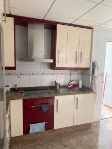 a kitchen with white cabinets and a sink at Apartamento terramarzarron in Mazarrón