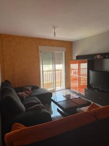 a living room with a couch and a flat screen tv at Apartamento terramarzarron in Mazarrón