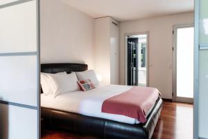 a bedroom with a large bed with white pillows at Garden Flat by Quokka 360 - Flat with private garden in Collina d'Oro