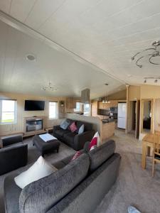 a large living room with a couch and a table at Pebble Beach Resort The Donington Lodge in Kinmel Bay