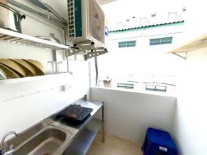 a small kitchen with a sink and a microwave at Patong Canal Villa 210 in Patong Beach