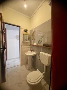 un baño con inodoro y lavabo en Syds Beach House, en Praia