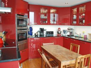 cocina con armarios rojos y mesa de madera en The Grand Terrace, en Saltburn-by-the-Sea