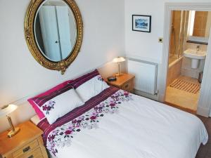 Un dormitorio con una cama blanca y un espejo. en The Grand Terrace, en Saltburn-by-the-Sea 7 fotos más