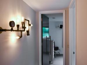 a hallway with a light fixture on a wall at Priory Barn in Freshwater