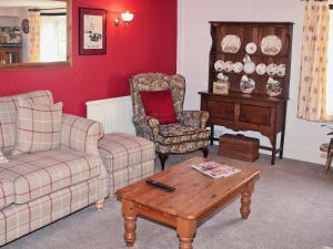 a living room with a couch and a chair and a table at Churchview House in Winterborne Abbas