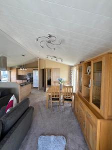 a living room with a couch and a table at Pebble Beach Resort The Donington Lodge in Kinmel Bay