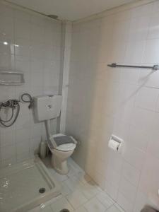 a white bathroom with a toilet and a shower at Zeus room 3 beds in Panagia