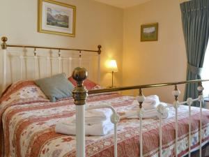 een slaapkamer met een bed met een wit bedframe bij Causey View in Keswick