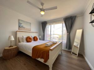 a bedroom with a bed with two pillows on it at Sunny Shores Retreat Spacious & Relaxing Escape in Lake Illawarra