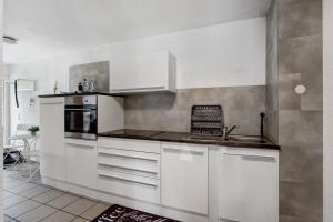 a kitchen with white cabinets and a stove at Ferienwohnung am Hof in Zwiefalten +16 photos