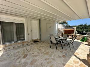 a patio with chairs and a table with an umbrella at Rouli's Houses by All About Paxos in Oziás