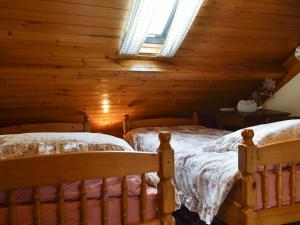 una camera con 2 letti in una baita di tronchi di Chapel Cottage a Pont Sticill Altre 5 foto