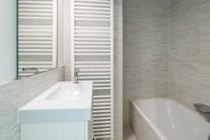 a bathroom with a sink and a bathtub and a sink at Zeewind 0101 in Oostduinkerke +13 photos