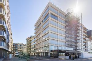 a tall building with glass in a city at Zeewind 0101 in Oostduinkerke