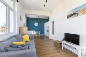 a living room with a couch and a tv at Ermitage 0204 P in Oostduinkerke