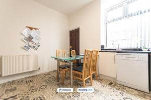 a kitchen with a table and chairs and a sink at Cosy 2BR House in Bolton with Free WiFi & Parking in Bolton +3 photos