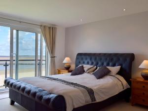 a bedroom with a large bed with a view of the ocean at Seaview in Llanelli +5 photos