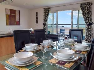a dining room table with plates and glasses on it at Seaview in Llanelli