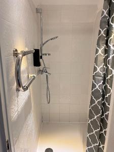 a shower in a bathroom with a shower curtain at Jūras Priedes in Ventspils +3 photos