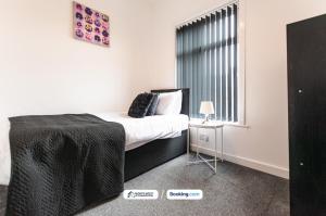 a bedroom with a large bed and a window at Cosy 2BR House in Bolton with Free WiFi & Parking in Bolton