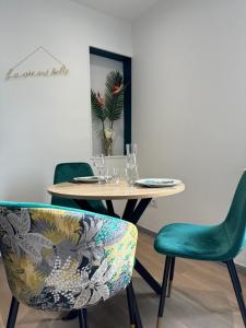 une table avec deux chaises et une table avec des verres dans l'établissement L'Oiseau du paradis - terrasse privée, parking, wifi rapide, arrivée autonome, entre gare et centre-ville, rez-de-chaussée, à Moulins