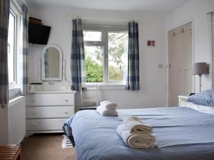 una camera da letto con un letto con asciugamani sopra di Cockle Cottage a Middleton-on-Sea