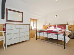 a bedroom with a bed with a dresser and a mirror at The Boot in Dulverton +9 photos