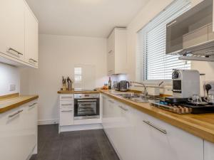 Una cocina con gabinetes blancos y encimera. en Copper's Rest - Uk41446, en Saltburn-by-the-Sea 4 fotos más