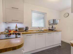 Una cocina blanca con gabinetes blancos y un fregadero. en Copper's Rest - Uk41446, en Saltburn-by-the-Sea