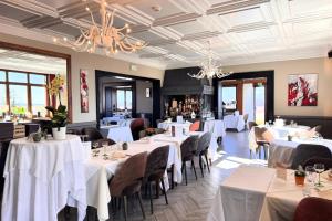 a dining room with white tables and chairs at Hotel Restaurant Au Riesling in Zellenberg