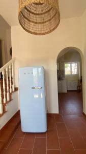 a white refrigerator in a hallway with a chandelier at Villa Saracena in Francavilla al Mare